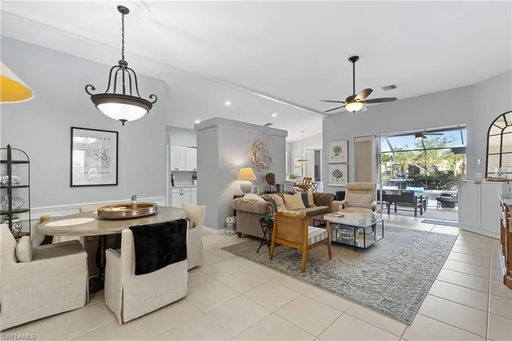 Tiled living room featuring ceiling fan and lofted ceiling