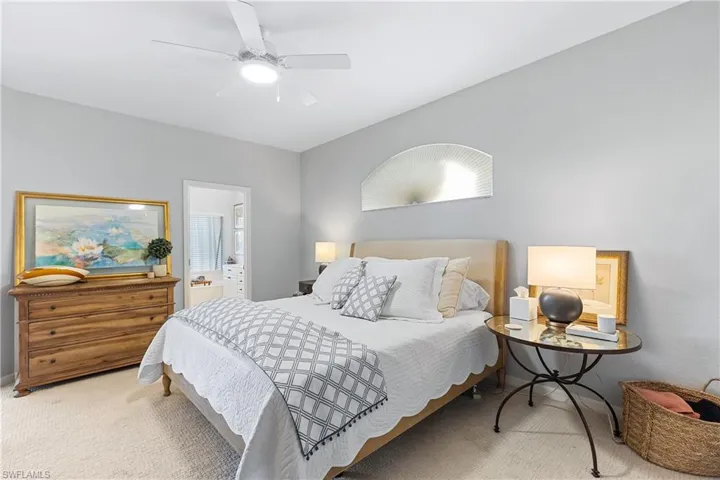Bedroom featuring carpet, ensuite bath, and ceiling fan