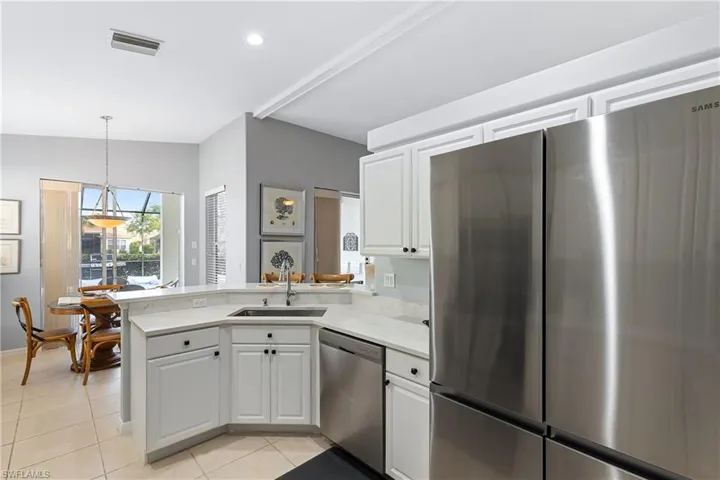 Kitchen featuring white cabinets, appliances with stainless steel finishes, kitchen peninsula, and sink