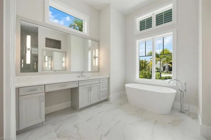 The primary bathroom features large scale tile, private water closet, dual vanities, soaking tub, and large shower with dual shower heads.