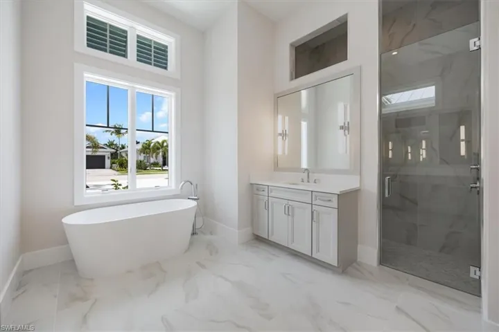 The primary bathroom features large scale tile, private water closet, dual vanities, soaking tub, and large shower with dual shower heads.