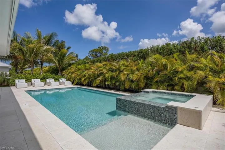 Outdoor living at its finest! Natural gas fireplace, motorized roll-down storm and bug screens, and a heated saltwater pool and spa complete this private outdoor haven.