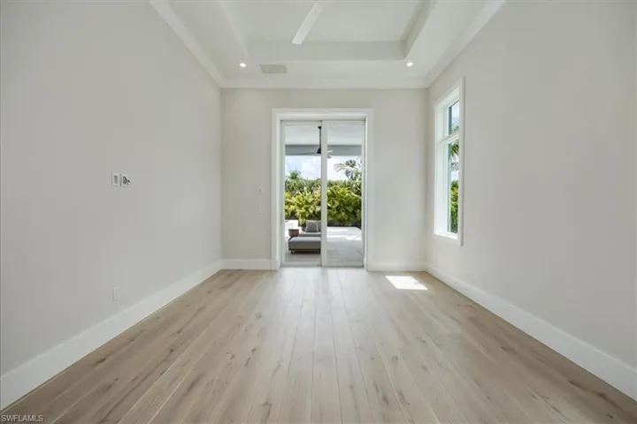 The primary bedroom features 10' sliders out to the pool deck, dual walk-in closets, and a generous primary bath.