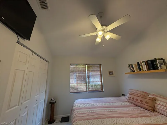 Bedroom featuring vaulted ceiling, a ceiling fan, and a closet