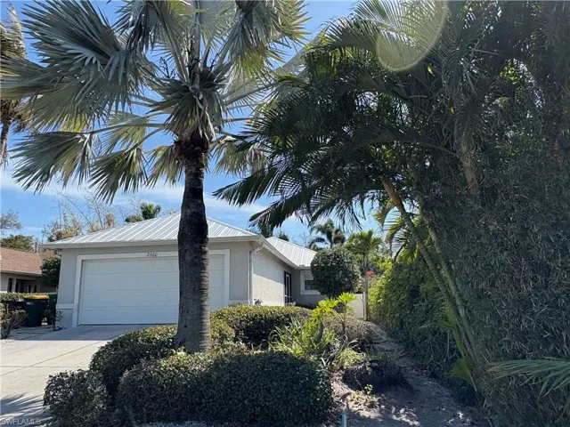 View of property exterior with an attached garage, stucco siding, and driveway