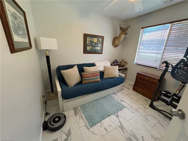 light marble finish flooring and a ceiling fan