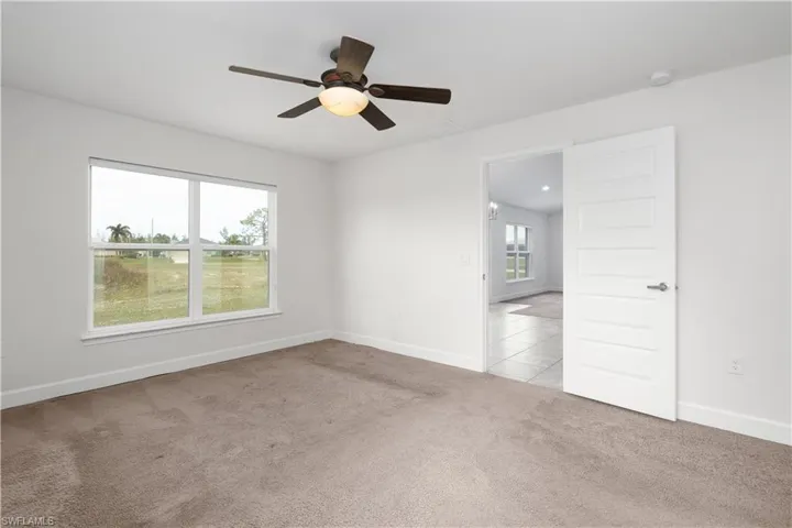 Carpeted spare room featuring ceiling fan