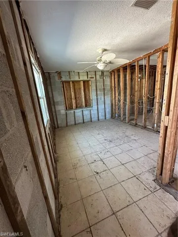 Misc room featuring ceiling fan and a textured ceiling