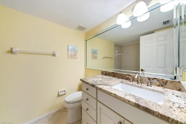 Bathroom with tile patterned floors, visible vents, toilet, and vanity