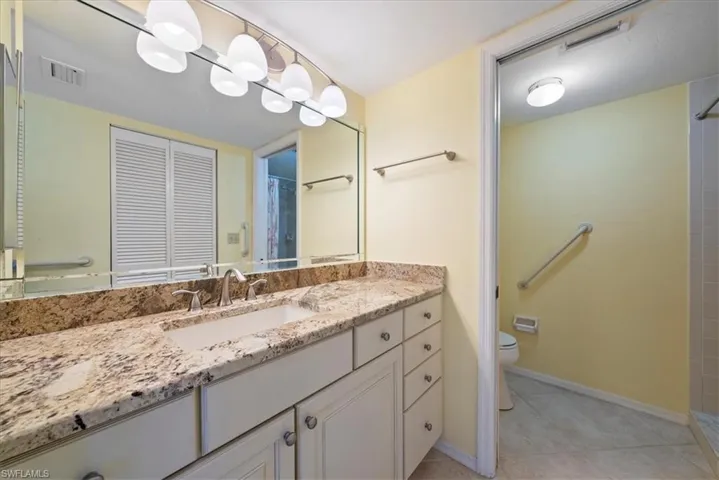 Full bathroom featuring tile patterned flooring, visible vents, toilet, a shower with shower curtain, and vanity