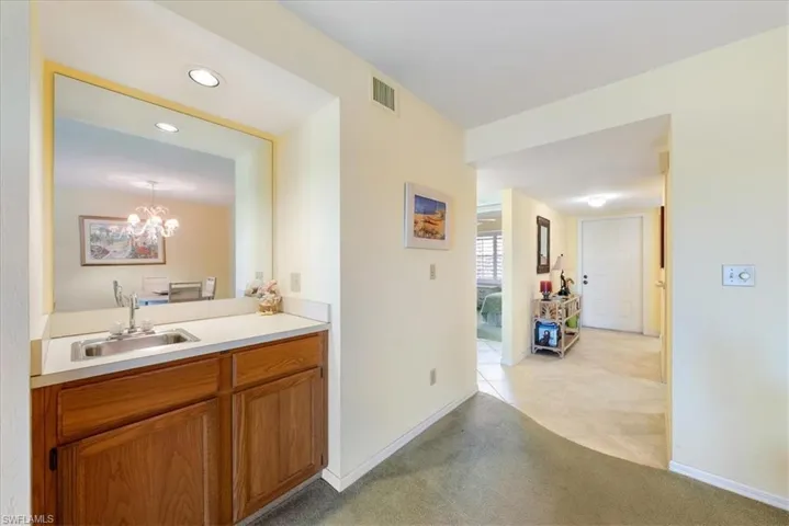 Bathroom featuring vanity, baseboards, visible vents, recessed lighting, and a chandelier