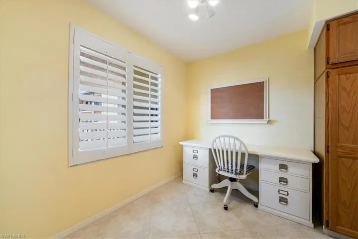 Office area featuring light tile patterned floors, built in study area, and baseboards