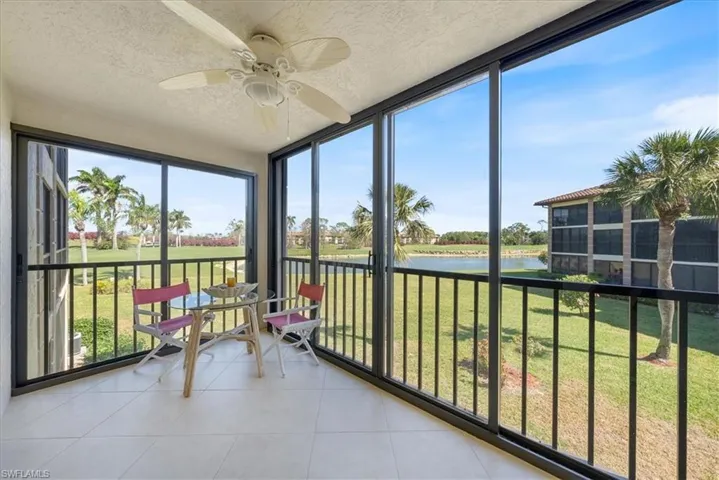 Unfurnished sunroom featuring tile patterned flooring, a textured ceiling, a water view, and ceiling fan