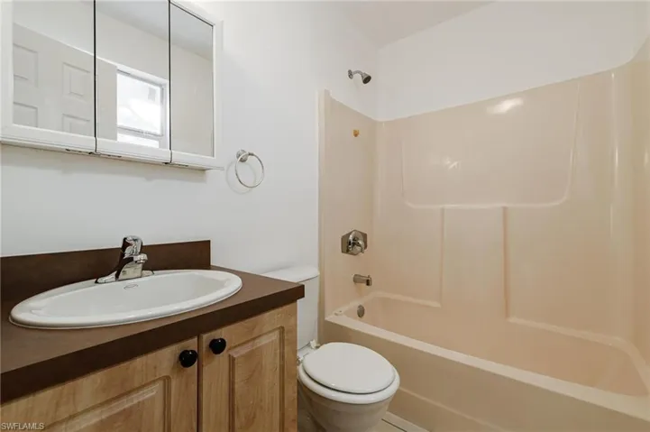 Full bathroom with vanity, washtub / shower combination, and toilet
