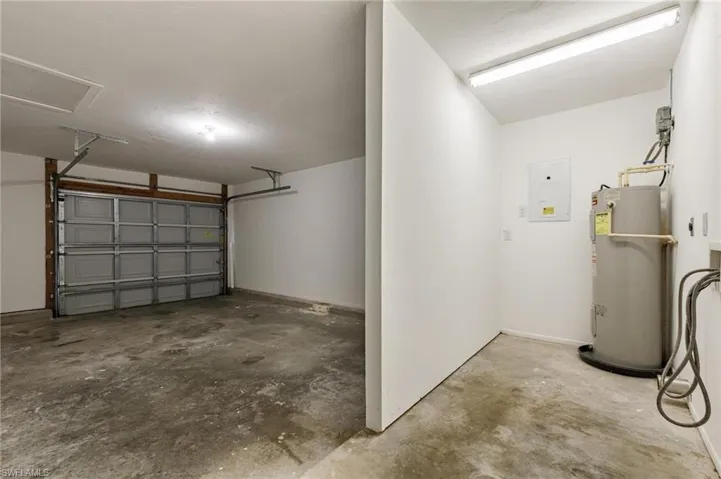 Garage featuring water heater and electric panel