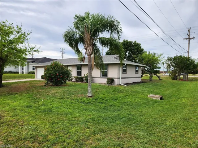 View of front facade featuring a garage and a front lawn