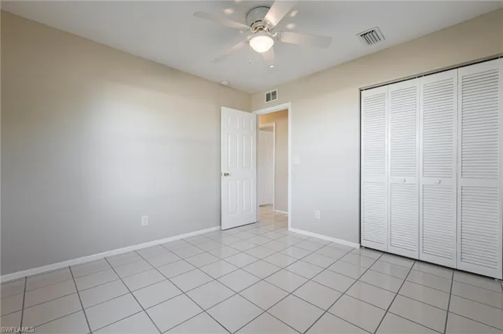 Unfurnished bedroom featuring light tile patterned floors, a closet, and ceiling fan