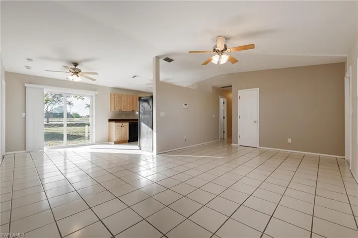 Unfurnished living room featuring ceiling fan, lofted ceiling, and light tile patterned floors