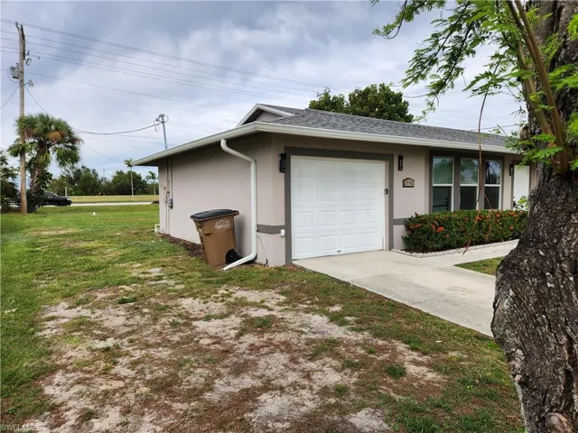 View of side of property featuring a yard and a garage