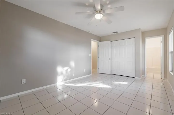 Unfurnished bedroom with a closet, ceiling fan, and light tile patterned floors