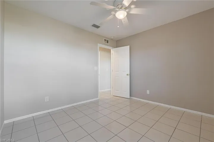 Spare room featuring light tile patterned flooring and ceiling fan