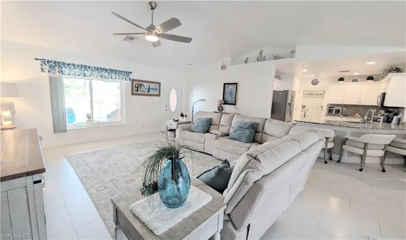Open-concept living area with vaulted ceilings and tile flooring