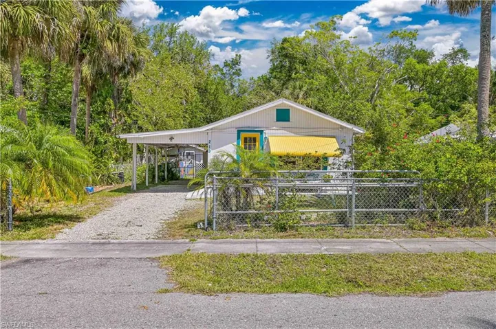 View of front of home with driveway and fence