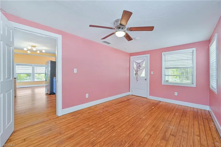Foyer with ceiling fan, a textured ceiling, visible vents, light wood finished floors, and baseboards