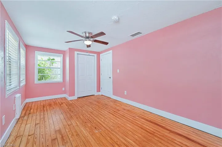 Unfurnished bedroom with light wood-style floors, visible vents, baseboards, and a ceiling fan