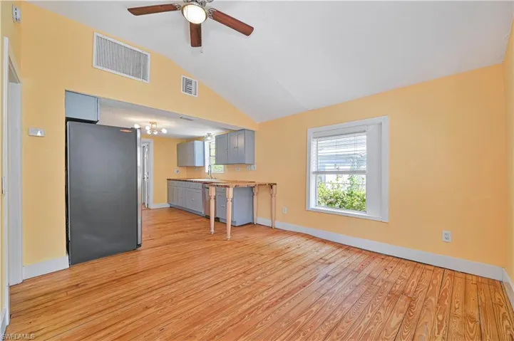 Kitchen with light wood-style flooring, a ceiling fan, vaulted ceiling, visible vents, and appliances with stainless steel finishes