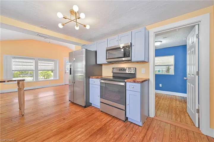 Kitchen with a chandelier, wooden counters, visible vents, appliances with stainless steel finishes, and light wood finished floors