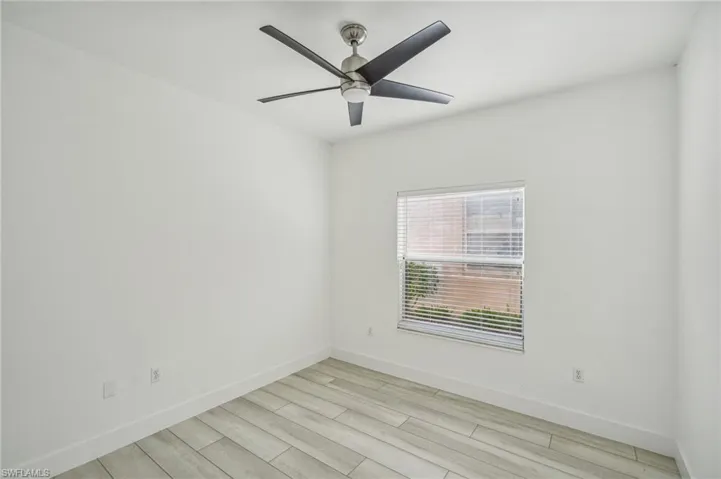 Empty room with light wood-type flooring, a ceiling fan, and baseboards
