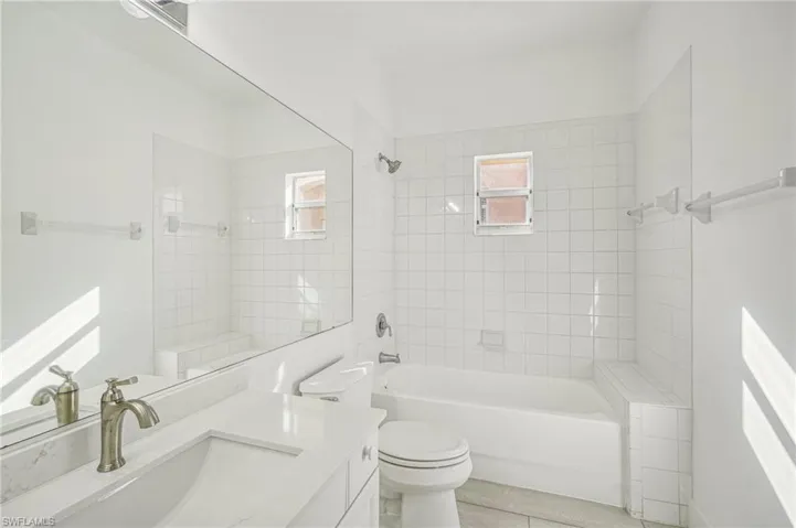 Full bathroom featuring vanity, plenty of natural light, tub / shower combination, and toilet
