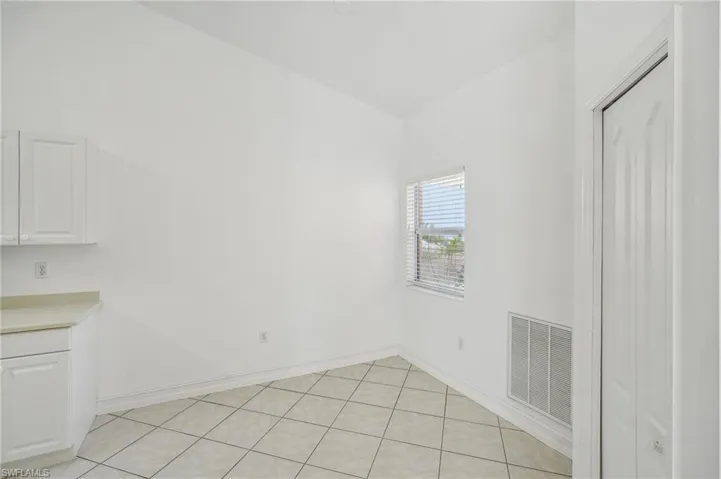 Unfurnished dining area featuring baseboards, lofted ceiling, and light tile patterned floors