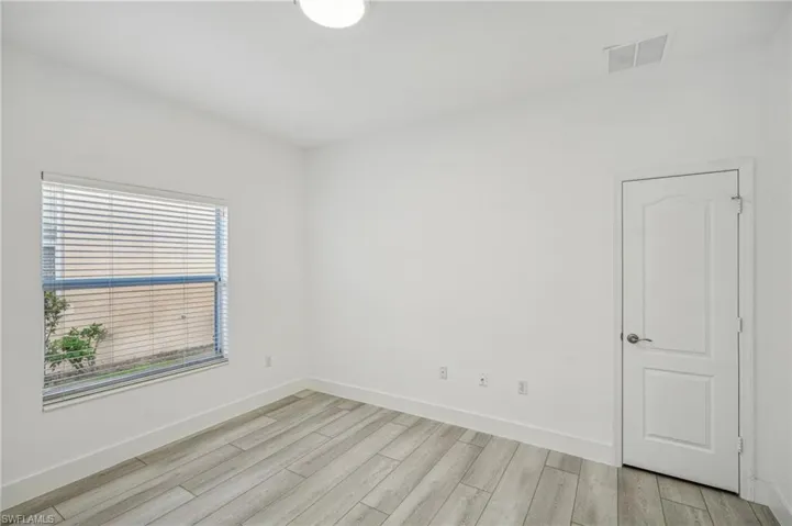 Empty room with light wood-type flooring and baseboards