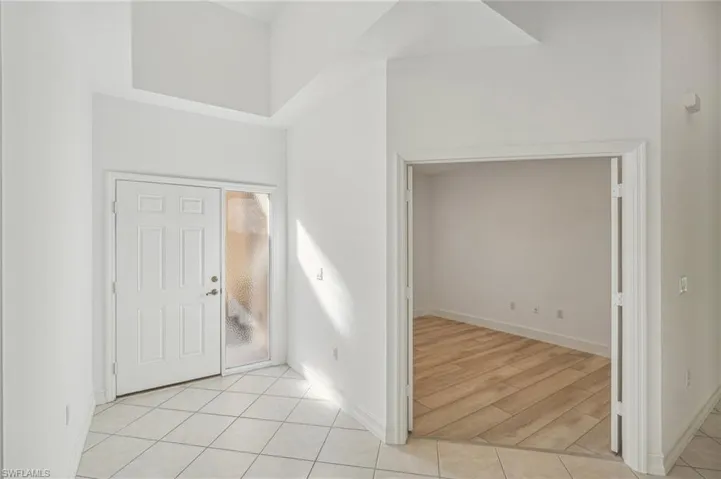Entryway featuring baseboards and light tile patterned floors