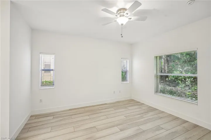 Empty room with light wood-type flooring, a ceiling fan, and baseboards