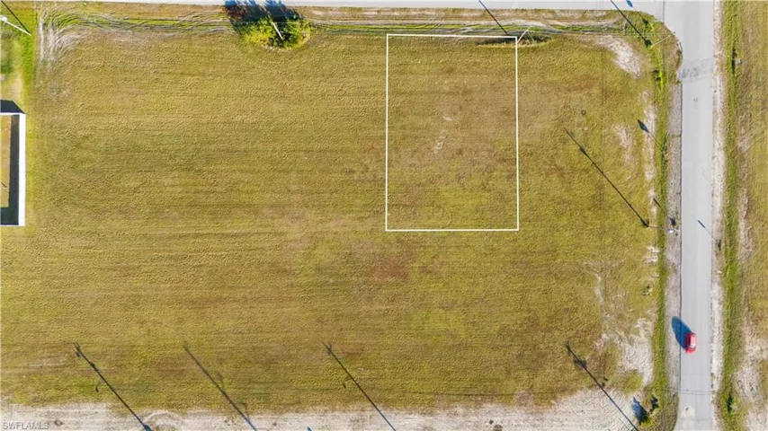 Expansive rectangular lot featuring a grassy surface and frontage on a paved road