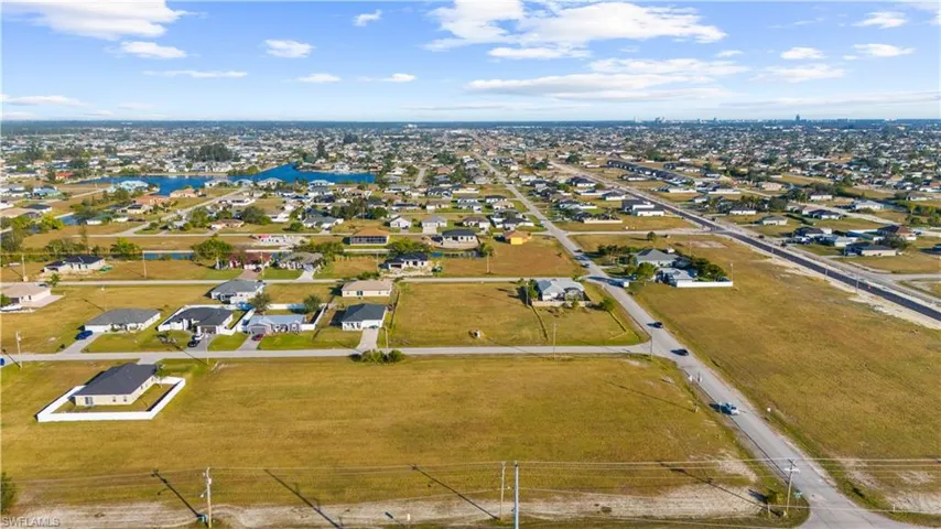 Aerial perspective showcasing multiple residential properties and undeveloped land parcels