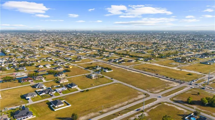 Expansive aerial capturing a suburban landscape with a mix of developed residential areas and undeveloped land parcels