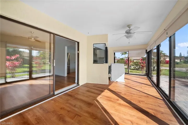 Unfurnished sunroom with a ceiling fan and wood finished floors