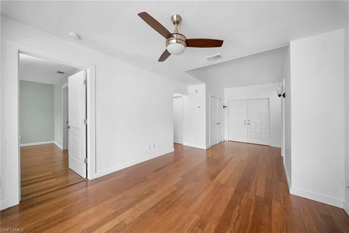 Unfurnished living room with dark wood finished floors and ceiling fan