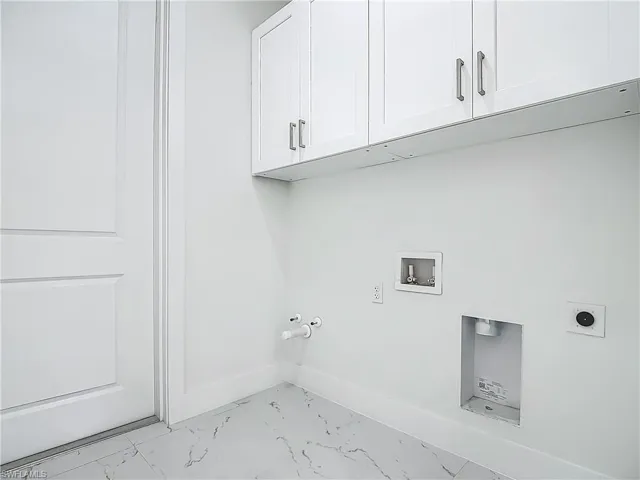 Laundry area featuring cabinet space, light marble finish flooring, hookup for a gas dryer, hookup for a washing machine, and hookup for an electric dryer