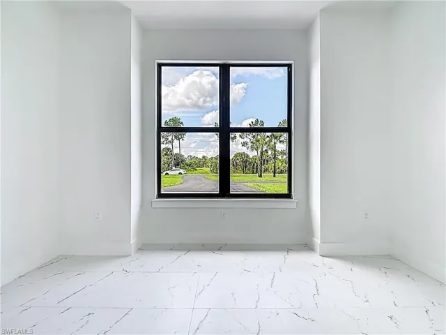 Spare room featuring marble finish flooring and healthy amount of natural light