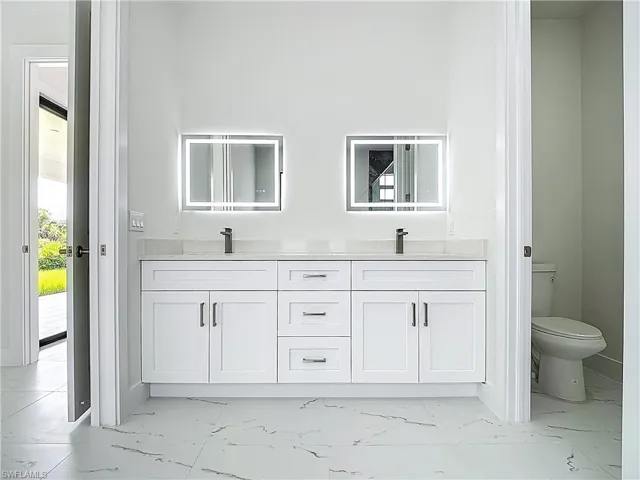 Bathroom featuring marble look tiles and double vanity
