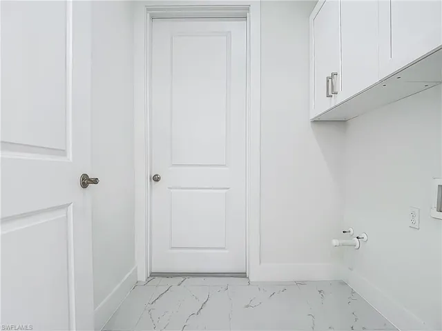 Laundry area featuring cabinet space, light marble finish flooring, hookup for a washing machine, and gas dryer hookup