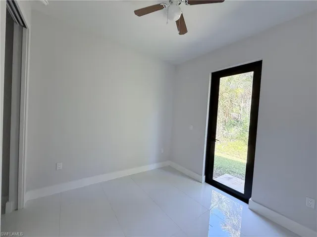 Unfurnished room with light tile patterned flooring and ceiling fan