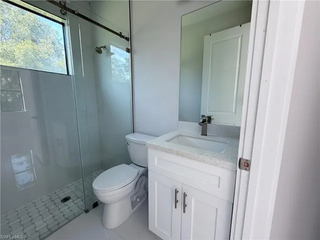 Bathroom featuring a shower stall, vanity, and tile patterned floors