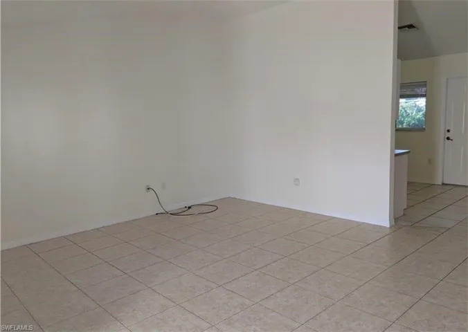 Spare room with light tile patterned flooring and baseboards