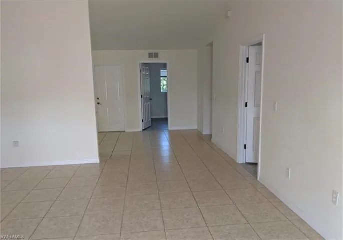 Spare room featuring light tile patterned floors and baseboards